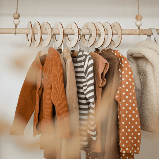 Houten kastverdeler op kledingroede voor baby- en kinderkleding, maat 50 t/m 98, met zon motief voor een georganiseerde kledingkast. Sfeerfoto.