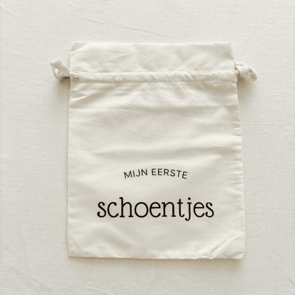 Katoenen bewaarzakje baby met de tekst 'Mijn eerste schoentjes' – ideaal om de eerste schoentjes van je baby veilig te bewaren - vooraanzicht