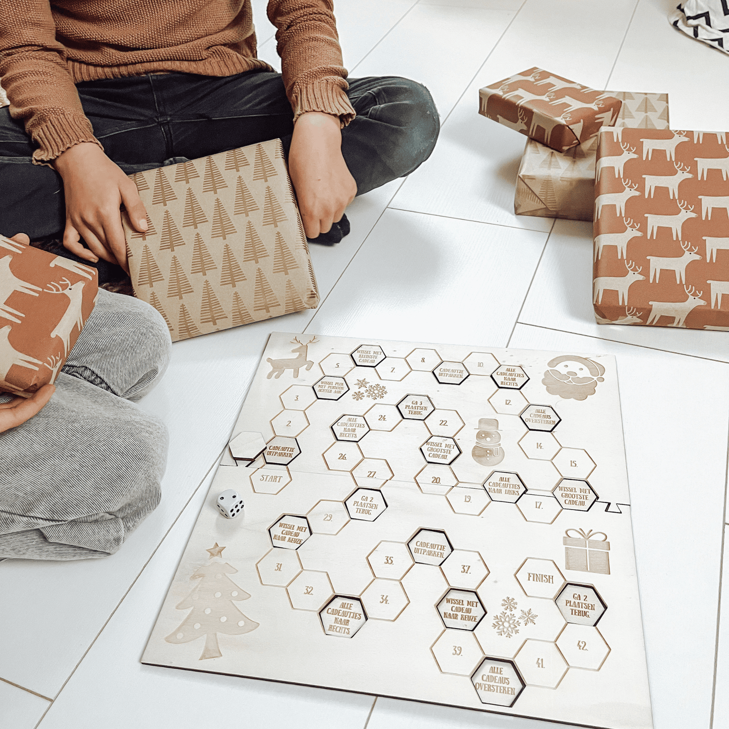 Bordspel kerst met 2 kinderen die het spel aan het spelen zijn met cadeaus - close-up – het leukste houten pakjesspel voor de feestdagen, perfect voor cadeau ruil en gezelligheid.