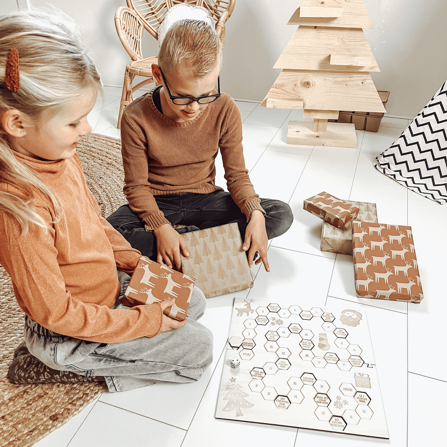 Bordspel kerst met 2 kinderen die het spel aan het spelen zijn met cadeaus en dobbelsteen – het leukste houten pakjesspel voor de feestdagen, perfect voor cadeau ruil en gezelligheid.