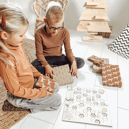 Bordspel kerst met 2 kinderen die het spel aan het spelen zijn met cadeaus en dobbelsteen – het leukste houten pakjesspel voor de feestdagen, perfect voor cadeau ruil en gezelligheid.