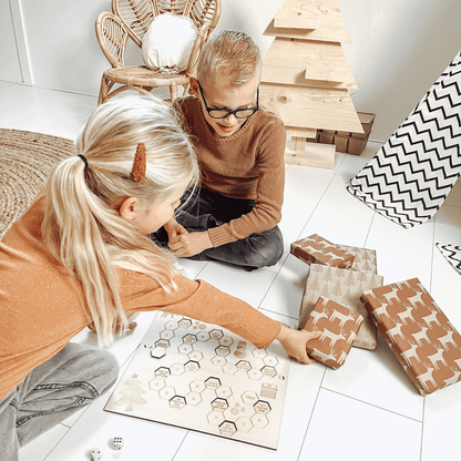 Bordspel kerst met 2 kinderen die het spel aan het spelen zijn met cadeaus – het leukste houten pakjesspel voor de feestdagen, perfect voor cadeau ruil en gezelligheid.