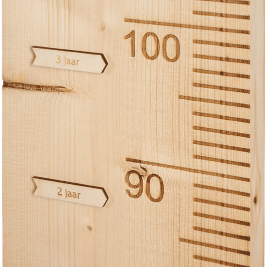 2 pijltjes op een houten groeimeter die de groei van je kind aangeven.