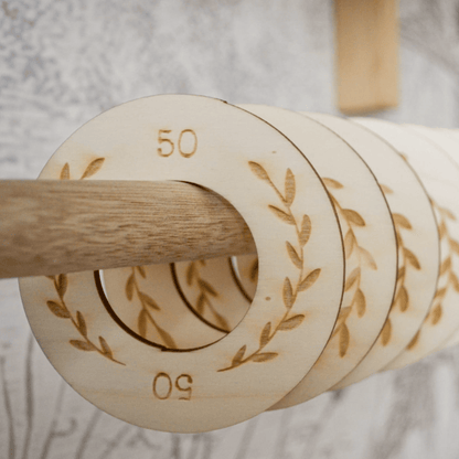 Houten kastverdeler op kledingroede voor baby- en kinderkleding, maat 50 t/m 98, met bladeren motief voor een georganiseerde kledingkast in detail.